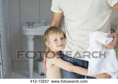 Stock Photo - Boy hugging father in bathroom. Fotosearch