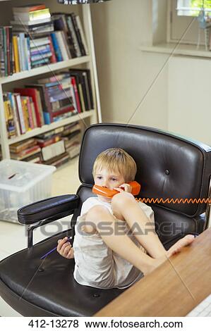 Stock Photo - Boy talking on telephone. Fotosearch
