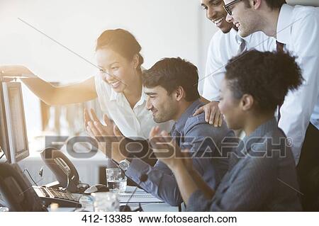 Business people cheering at computer in office View Large Photo Image Stock Photography - Business people cheering at computer in office. Fotosearch