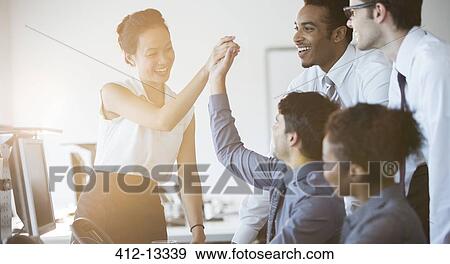 Business people cheering in office View Large Photo Image Stock Photo - Business people cheering in office. Fotosearch