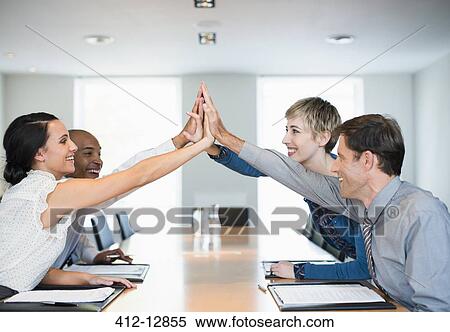 Business people high fiving in office View Large Photo Image Stock Photography - Business people high fiving in office. Fotosearch