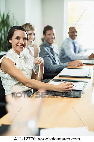 Stock Image - Business people sitting in meeting. Fotosearch