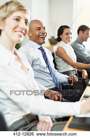 Stock Photograph - Business people smiling in meeting. Fotosearch
