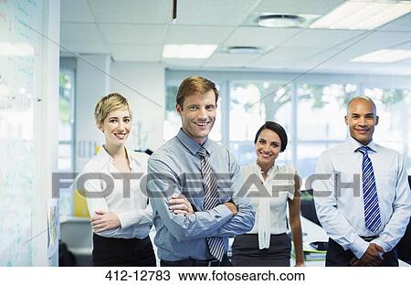 Stock Image - Business people smiling in office. Fotosearch