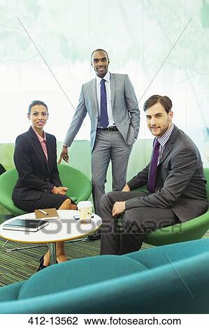 Stock Image - Business people smiling in office. Fotosearch