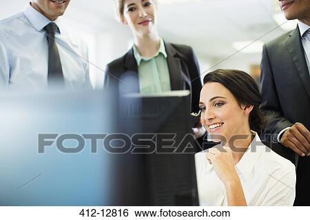Business people talking at computer in office View Large Photo Image Stock Photograph - Business people talking at computer in office. Fotosearch