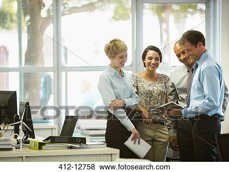 Stock Photo - Business people with digital tablet talking in office. Fotosearch