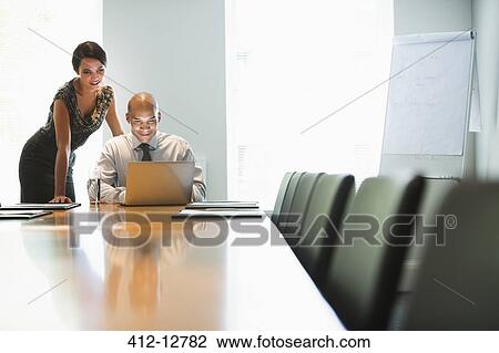 Business people working at laptop in conference room View Large Photo Image Stock Image - Business people working at laptop in conference room. Fotosearch