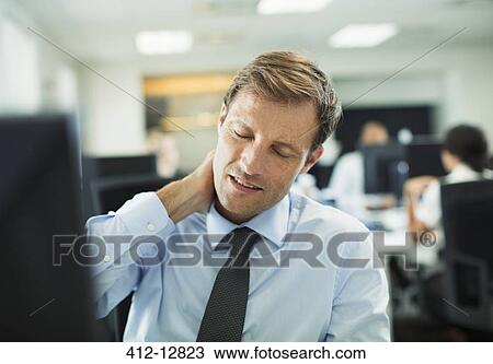 Businessman rubbing his neck in office View Large Photo Image Stock Image - Businessman rubbing his neck in office. Fotosearch