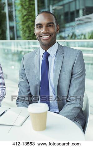 Businessman smiling at sidewalk cafe View Large Photo Image Stock Image - Businessman smiling at sidewalk cafe. Fotosearch