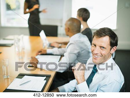 Businessman smiling in meeting View Large Photo Image Stock Image - Businessman smiling in meeting. Fotosearch