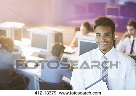 Stock Photo - Businessman smiling in office. Fotosearch