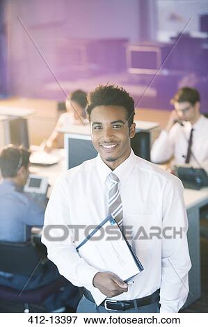 Businessman smiling in office View Large Photo Image Stock Photo - Businessman smiling in office. Fotosearch