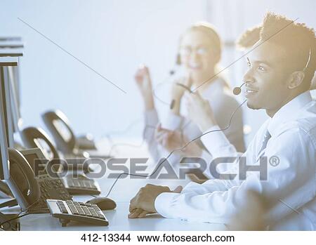 Businessman talking on headset in office View Large Photo Image Picture - Businessman talking on headset in office. Fotosearch