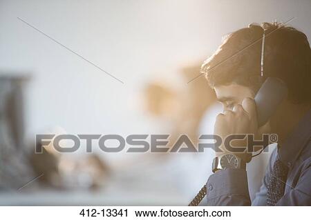 Businessman talking on telephone in office View Large Photo Image Stock Image - Businessman talking on telephone in office. Fotosearch