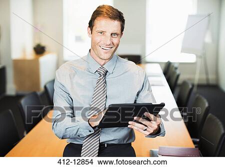 Businessman using digital tablet in office View Large Photo Image Picture - Businessman using digital tablet in office. Fotosearch