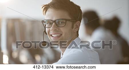 Businessman wearing headset in office View Large Photo Image Picture - Businessman wearing headset in office. Fotosearch