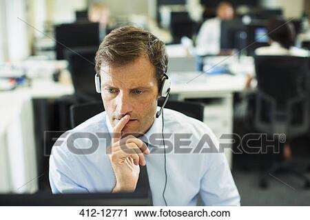 Businessman wearing headset in office View Large Photo Image Stock Image - Businessman wearing headset in office. Fotosearch