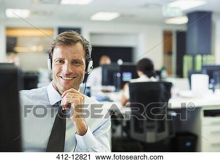 Businessman wearing headset in office View Large Photo Image Stock Image - Businessman wearing headset in office. Fotosearch