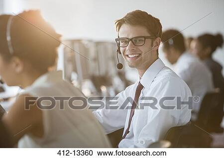 Businessman wearing headset in office View Large Photo Image Stock Image - Businessman wearing headset in office. Fotosearch