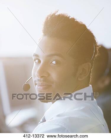 Businessman wearing headset in office View Large Photo Image Stock Image - Businessman wearing headset in office. Fotosearch