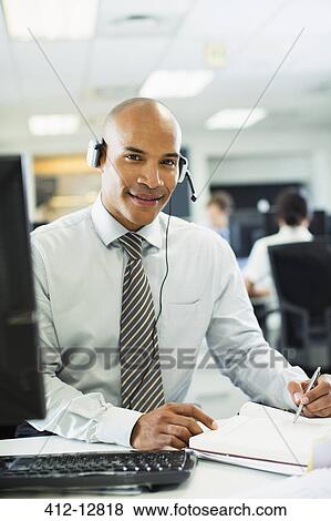 Businessman wearing headset in office View Large Photo Image Stock Photo - Businessman wearing headset in office. Fotosearch