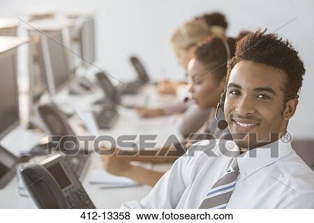 Stock Photo - Businessman wearing headset in office. Fotosearch