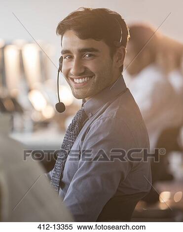 Stock Photography - Businessman wearing headset in office. Fotosearch