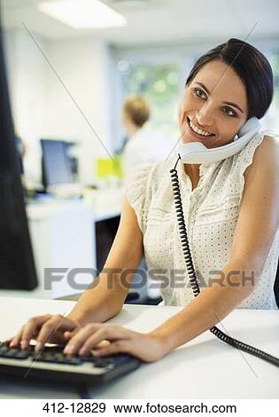 Businessman working at desk in office View Large Photo Image Stock Photo - Businessman working at desk in office. Fotosearch