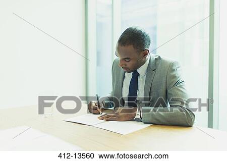 Stock Image - Businessman writing in office. Fotosearch