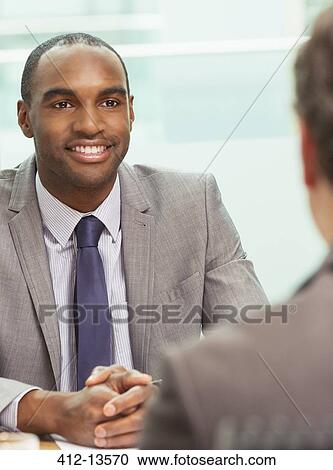 Stock Image - Businessmen talking in meeting. Fotosearch