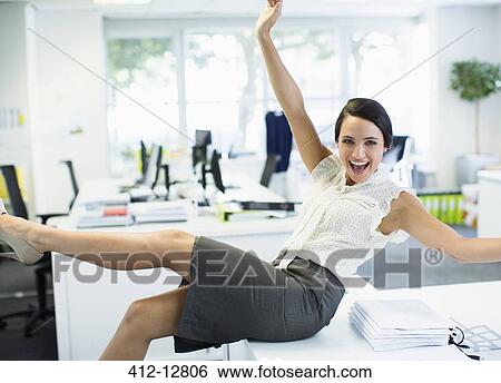 Businesswoman cheering in office View Large Photo Image Stock Photograph - Businesswoman cheering in office. Fotosearch