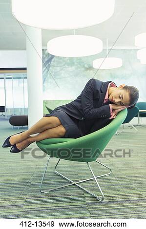 Stock Photo - Businesswoman napping in office chair. Fotosearch