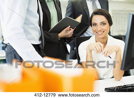 Businesswoman smiling at computer in office View Large Photo Image Stock Photo - Businesswoman smiling at computer in office. Fotosearch