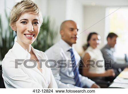 Picture - Businesswoman smiling in meeting. Fotosearch