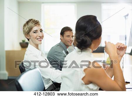 Stock Image - Businesswoman smiling in meeting. Fotosearch