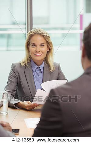 Stock Image - Businesswoman smiling in meeting. Fotosearch