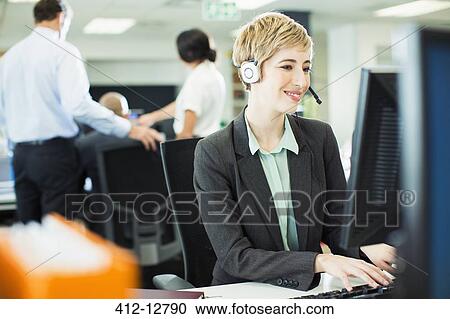Businesswoman talking on headset in office View Large Photo Image Stock Image - Businesswoman talking on headset in office. Fotosearch