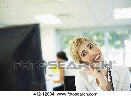 Businesswoman talking on telephone in office View Large Photo Image Picture - Businesswoman talking on telephone in office. Fotosearch
