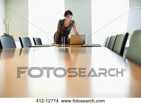 Businesswoman using laptop at conference table View Large Photo Image Picture - Businesswoman using laptop at conference table. Fotosearch