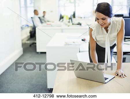 Stock Photo - Businesswoman using laptop in office. Fotosearch
