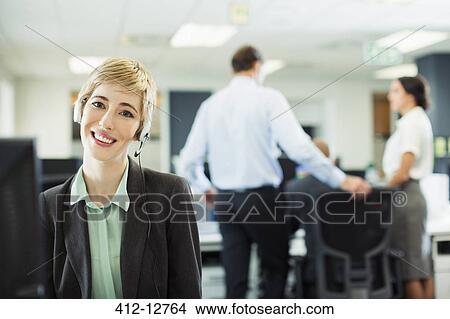 Businesswoman wearing headset in office View Large Photo Image Picture - Businesswoman wearing headset in office. Fotosearch