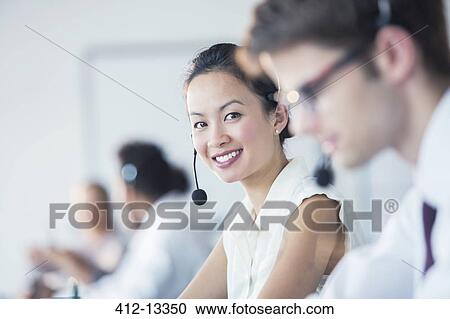 Businesswoman wearing headset in office View Large Photo Image Stock Image - Businesswoman wearing headset in office. Fotosearch