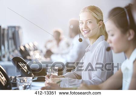 Businesswoman wearing headset in office View Large Photo Image Stock Image - Businesswoman wearing headset in office. Fotosearch