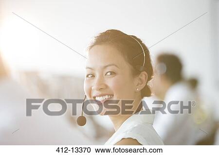 Businesswoman wearing headset in office View Large Photo Image Stock Image - Businesswoman wearing headset in office. Fotosearch