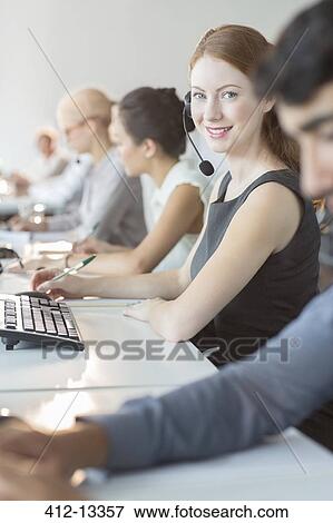 Businesswoman wearing headset in office View Large Photo Image Stock Photo - Businesswoman wearing headset in office. Fotosearch