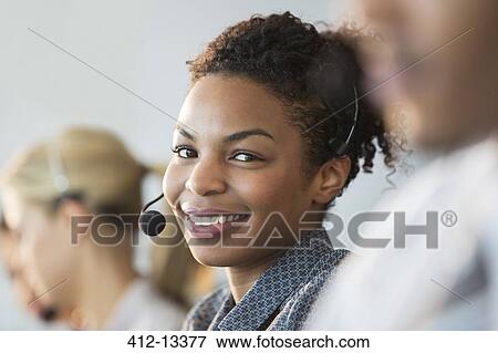 Businesswoman wearing headset in office View Large Photo Image Stock Photo - Businesswoman wearing headset in office. Fotosearch