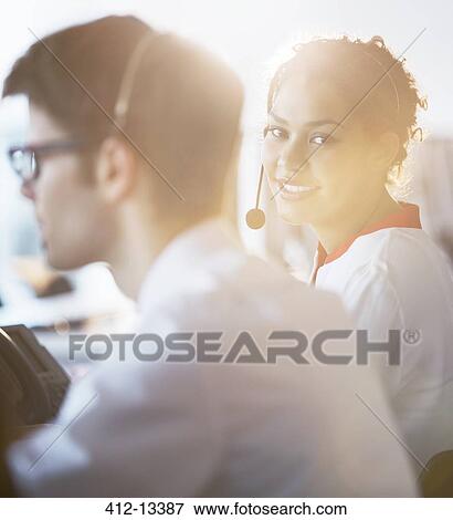 Stock Photo - Businesswoman wearing headset in office. Fotosearch