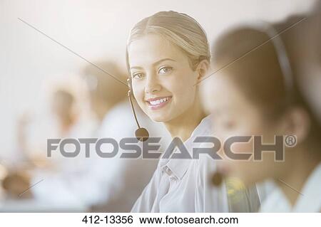 Businesswoman wearing headset in office View Large Photo Image Stock Photograph - Businesswoman wearing headset in office. Fotosearch