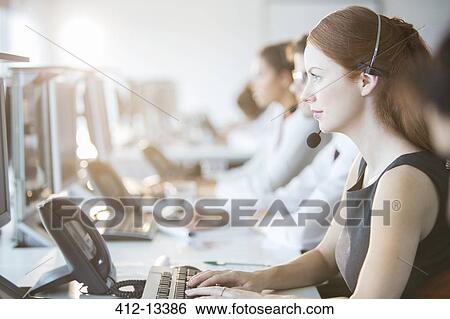 Stock Photograph - Businesswoman wearing headset in office. Fotosearch